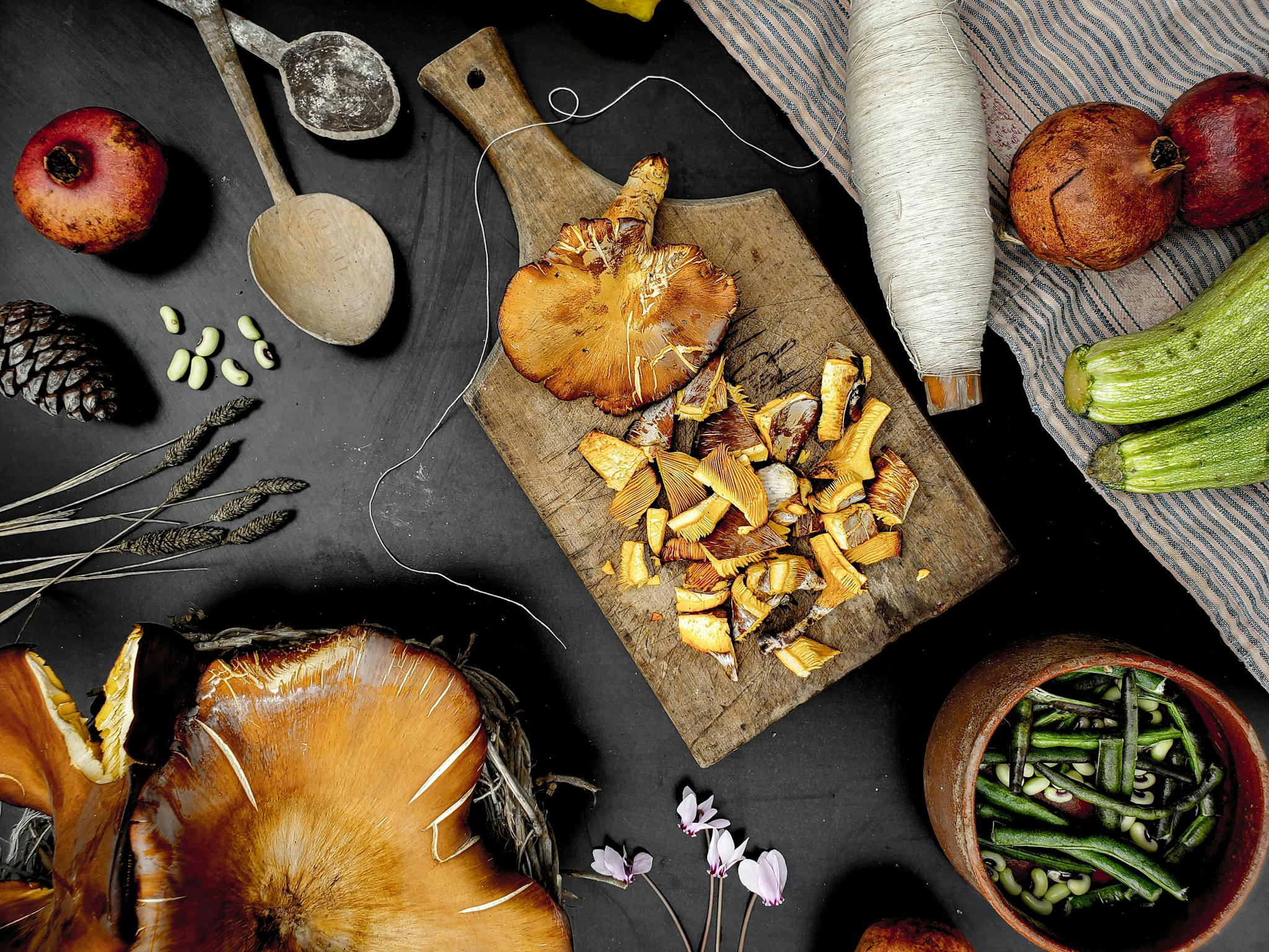 Artistic arrangement of fresh vegetables and mushrooms on a wooden board, showcasing a rustic still life setting.